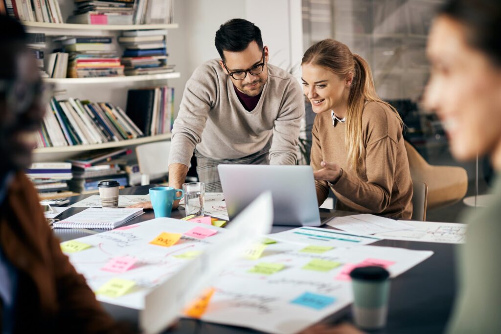 Équipe réunie autour d'une table couverte de post-its et de documents pour construire un plan de communication interne