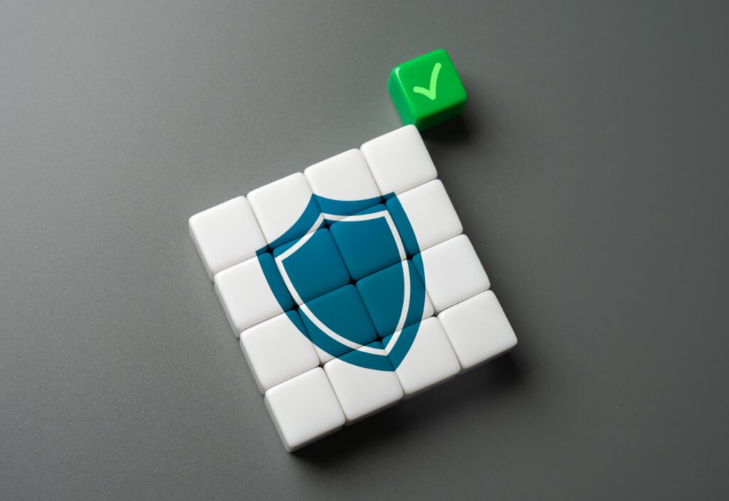 Représentation visuelle d'un bouclier de sécurité numérique composé de blocs blancs avec une coche verte, symbolisant la protection et la conformité des données.