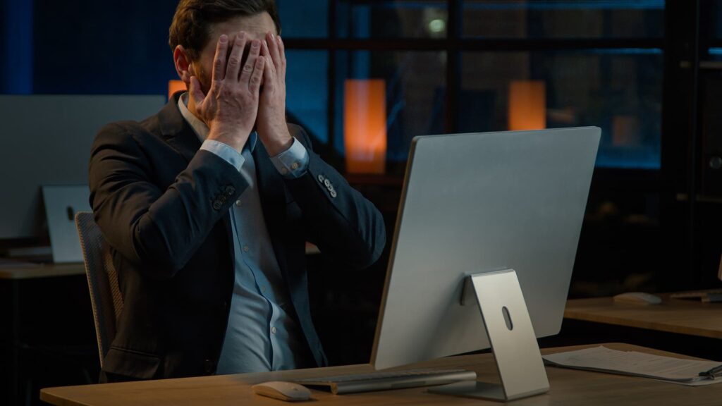 Un collaborateur en difficulté devant son écran après une fuite d'informations professionnelles sensibles