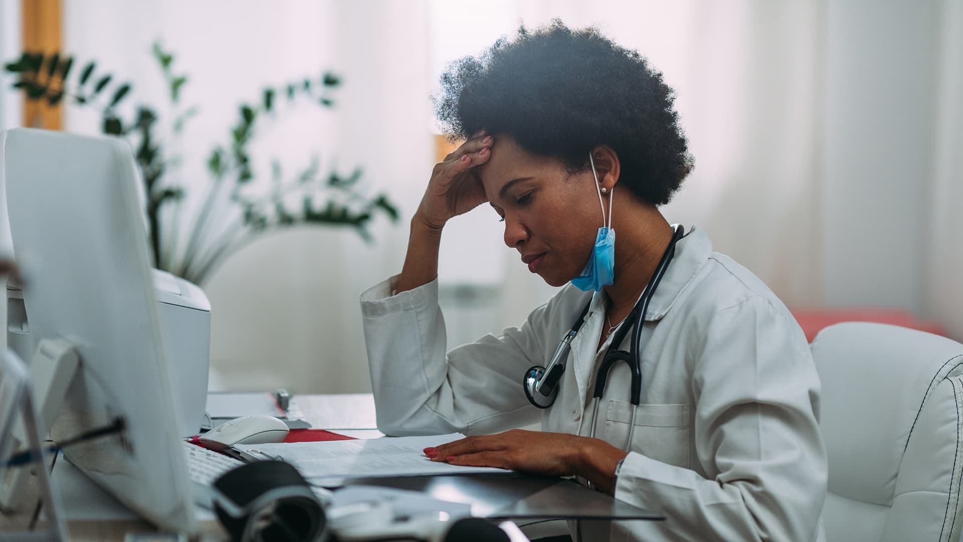 Médecin épuisée face à la surcharge d'informations et de mails à l'hôpital